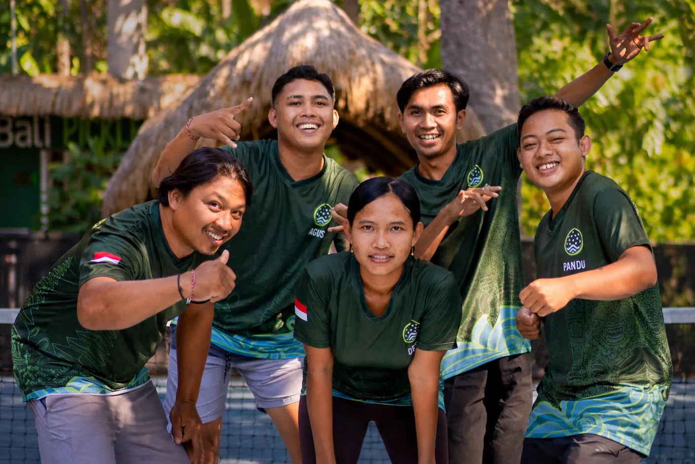 Barefoot kids playing pickleball under the jungle canopy