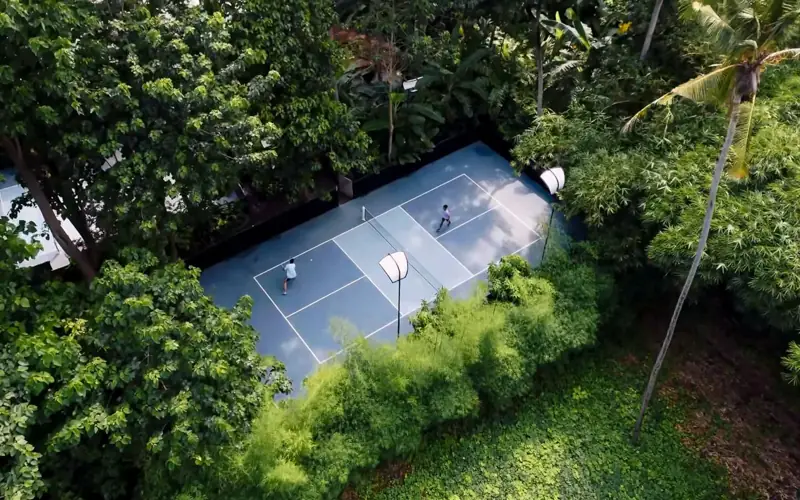Aerial view of court surrounded by jungle canopy
